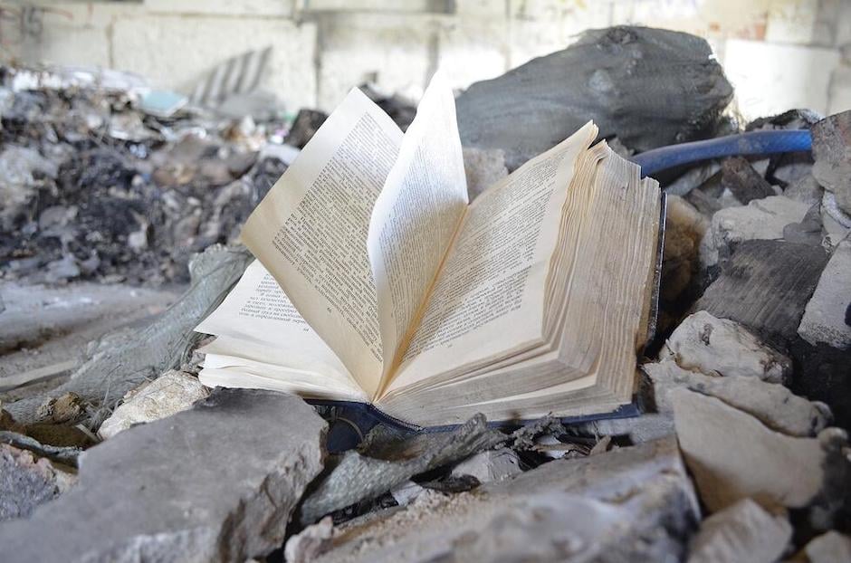open book sitting in pile of rubble
