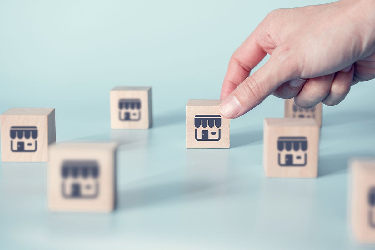 hand setting down cube with GMB icon printed on outside surrounded by other cubes