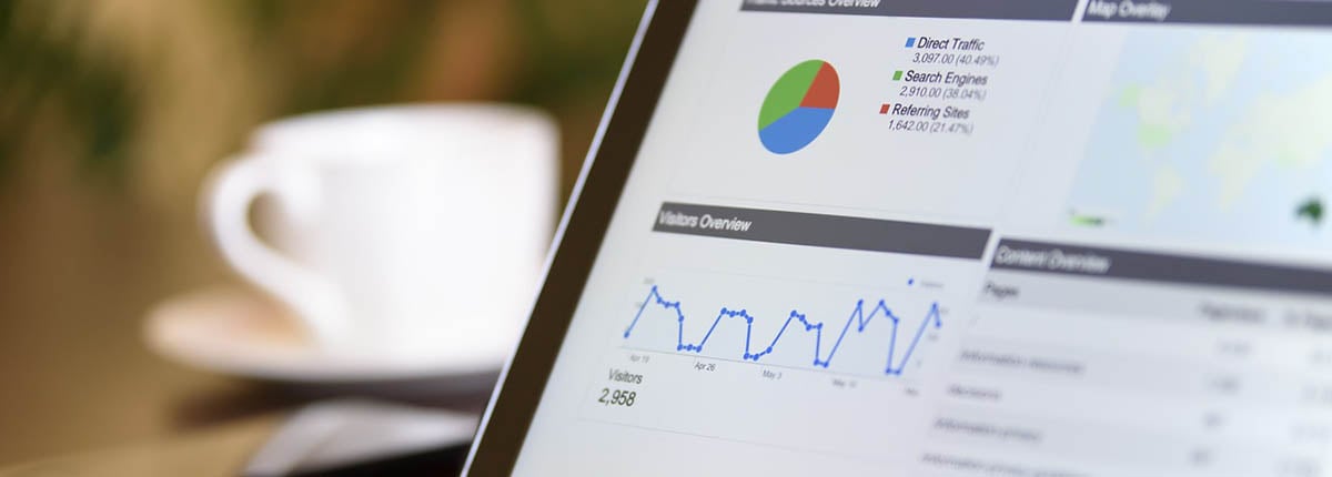 analytics report displayed on laptop screen with coffee cup in background